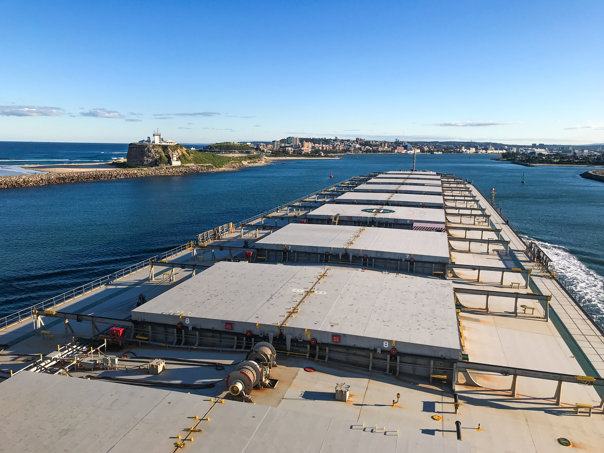 View from the pilot bridge aboard a bulk carrier entering Newcastle on a sunny day passing Nobbys Lighthouse on the left