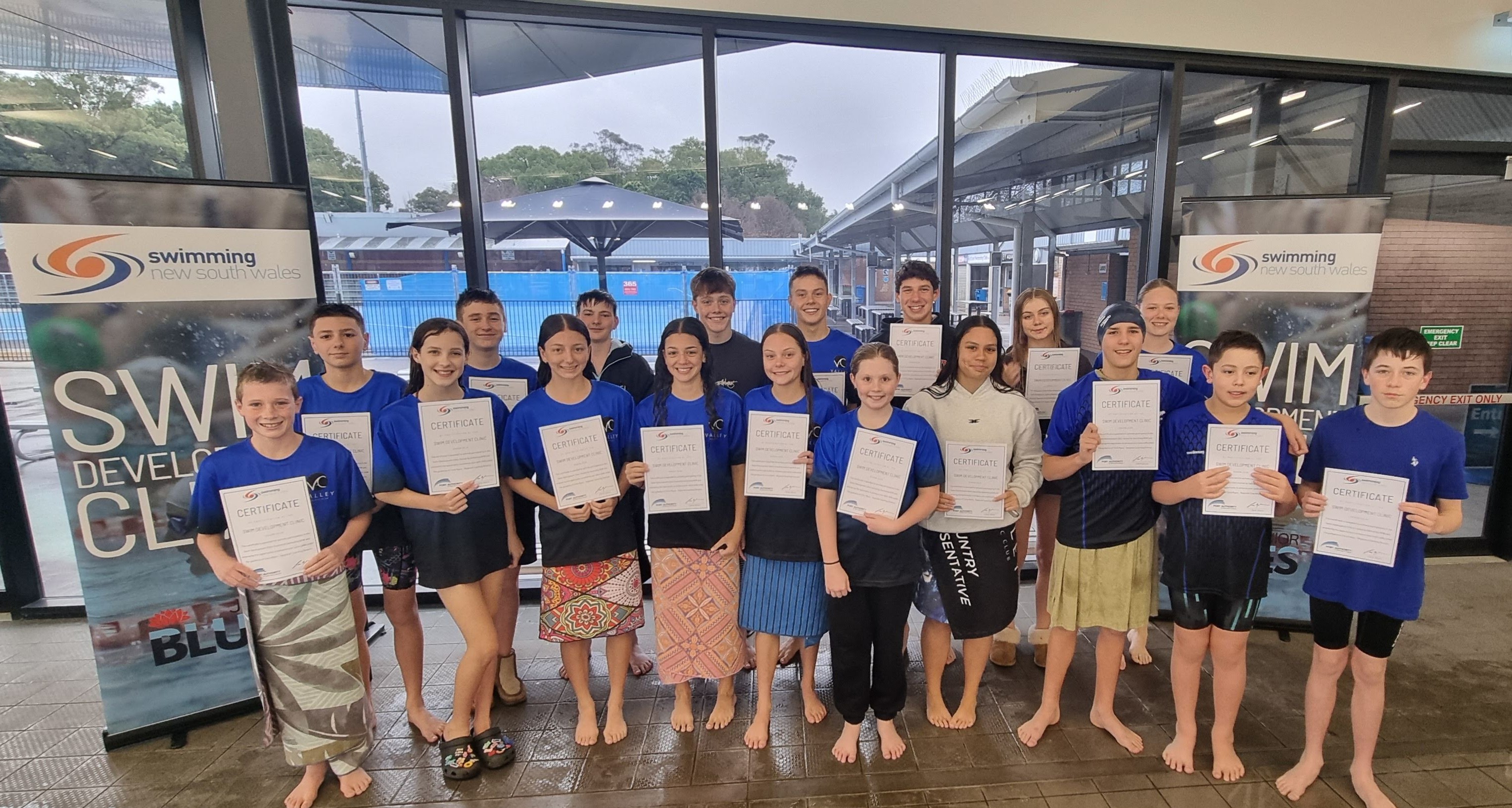 Children holding participation certificates for completing a Swimming NSW swim clinic