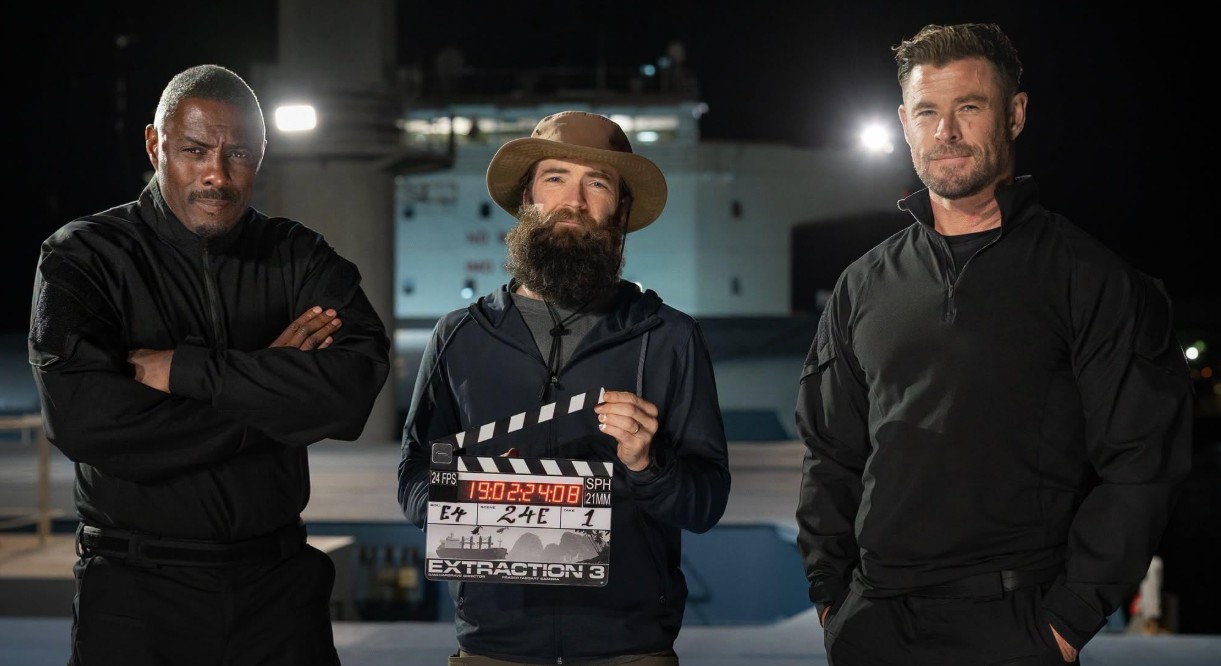 Idris Elba, Extraction director, and Chris Hemsworth pose in front of Port Kembla