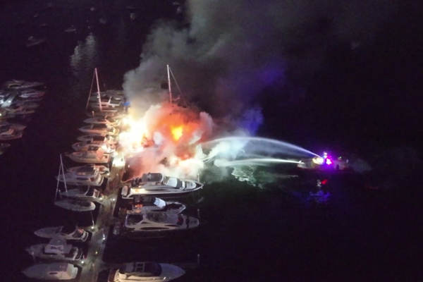 A Port Authority vessel pumps water onto several yachts on fire
