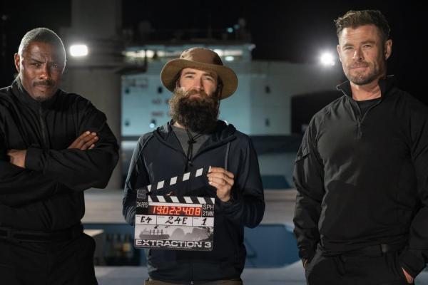 Idris Elba, Extraction director, and Chris Hemsworth pose in front of Port Kembla