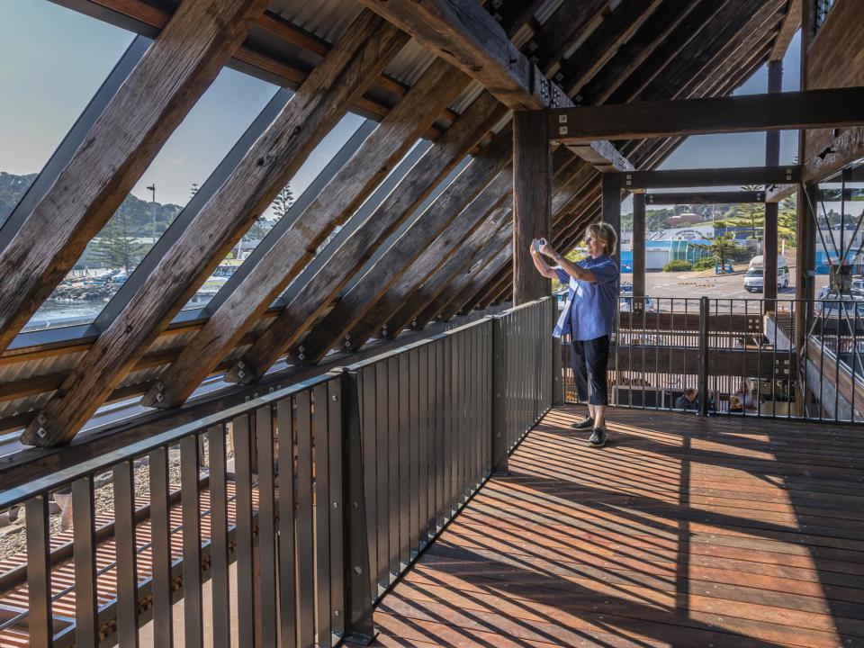 A woman takes a photo looking out from inside the second floor of Eden Welcome Centre