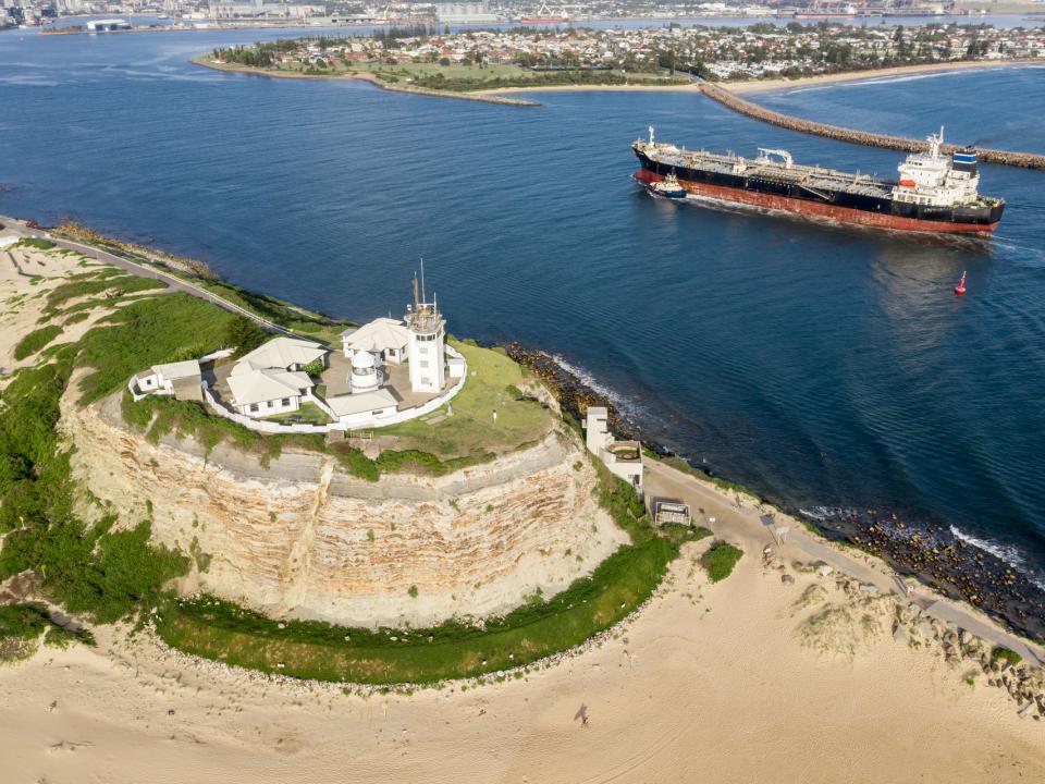 Aerial of Nobbys Headland with a ship entering the mouth of Port of Newcastle