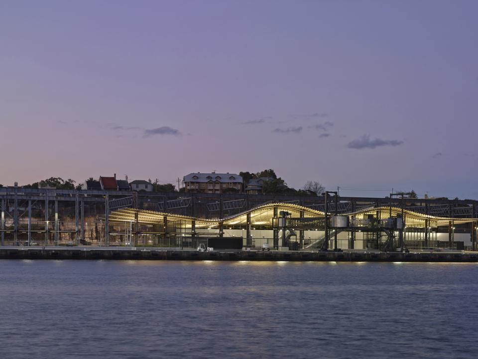 Looking across the water at White Bay Cruise Terminal at dusk illuminated by its lights on
