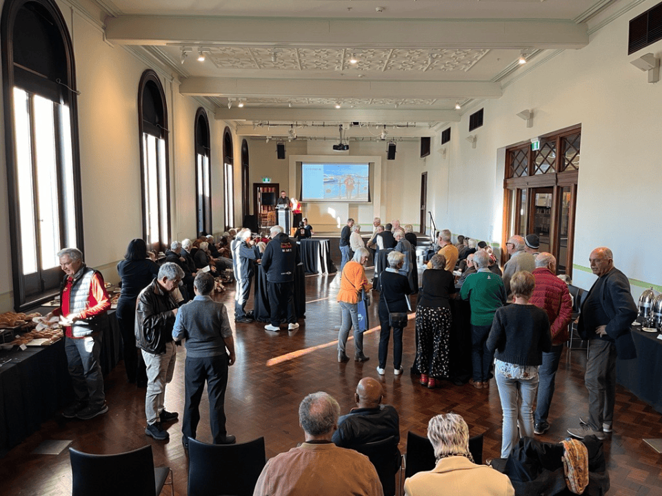 Group of people standing and chatting inside a town hall