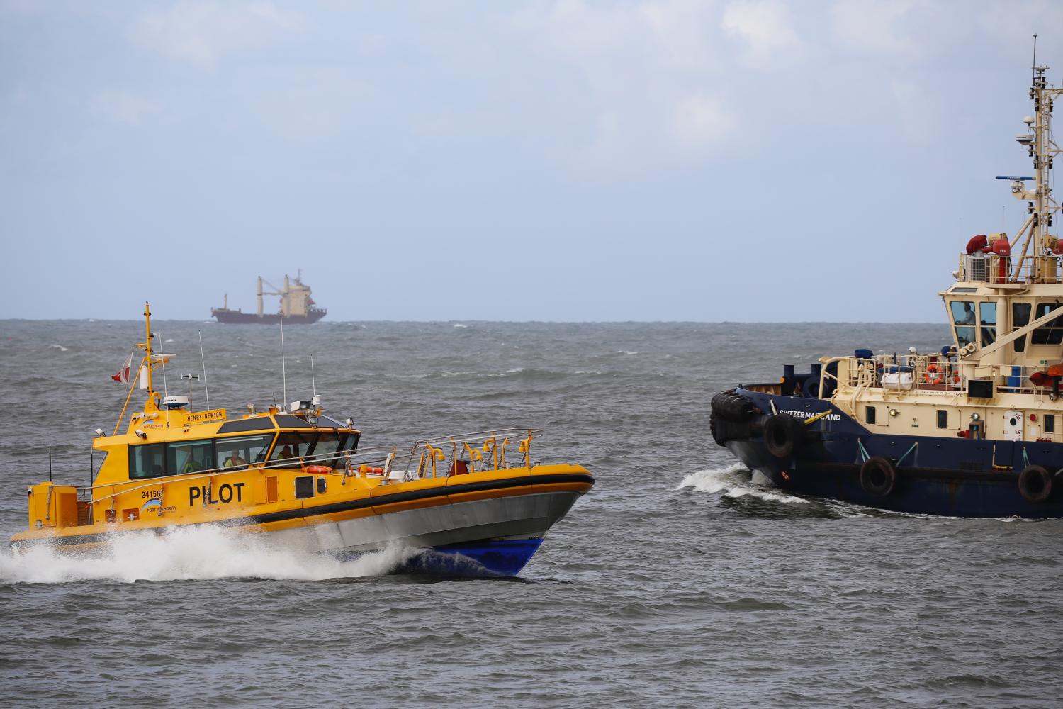 Pilot cutter vessel next to a tug on the water