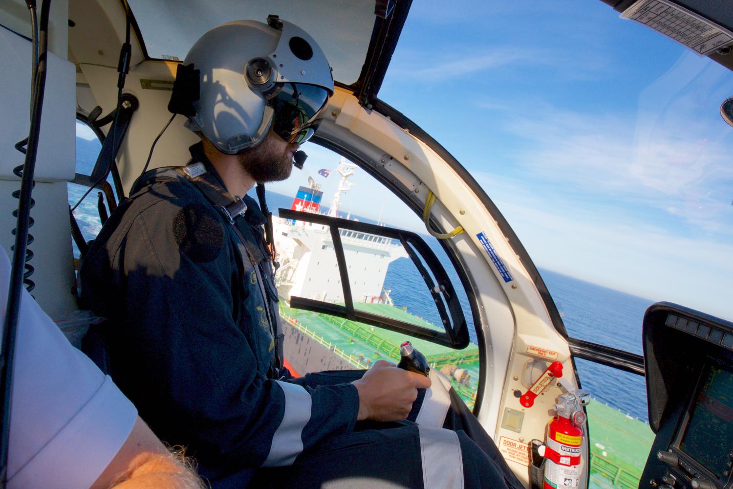 A pilot on a helicopter about to land on a ship
