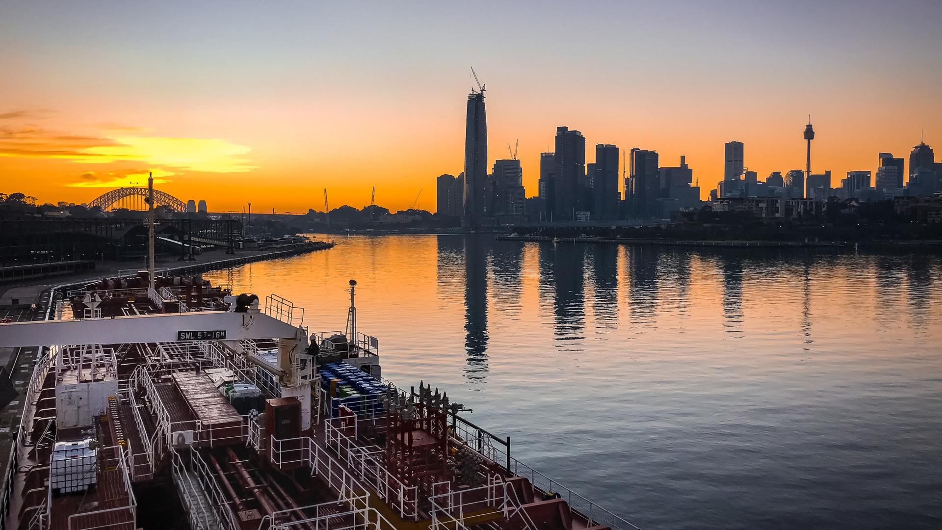 Bulk carrier moored alongside White Bay at sunrisewith Sydney CBD and Harbour Bridge in background