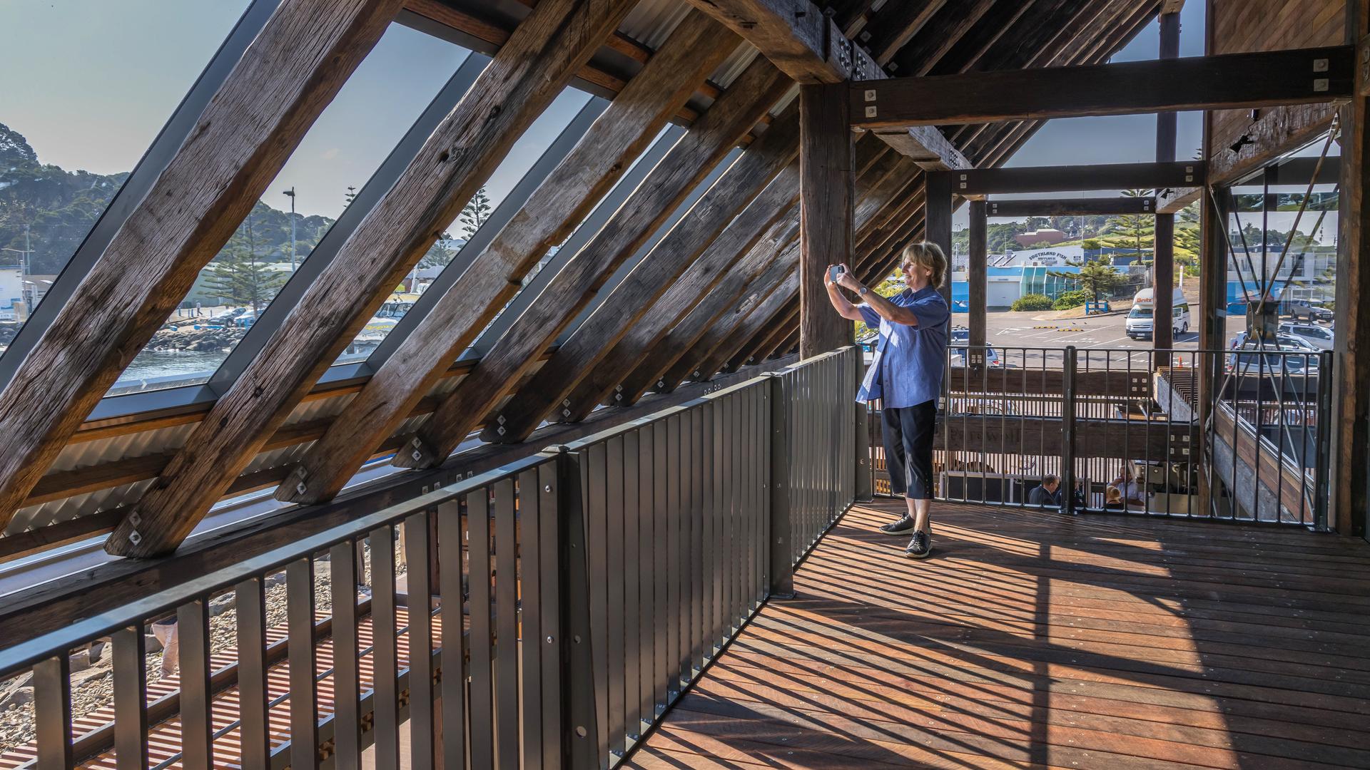 A woman takes a photo looking out from inside the second floor of Eden Welcome Centre