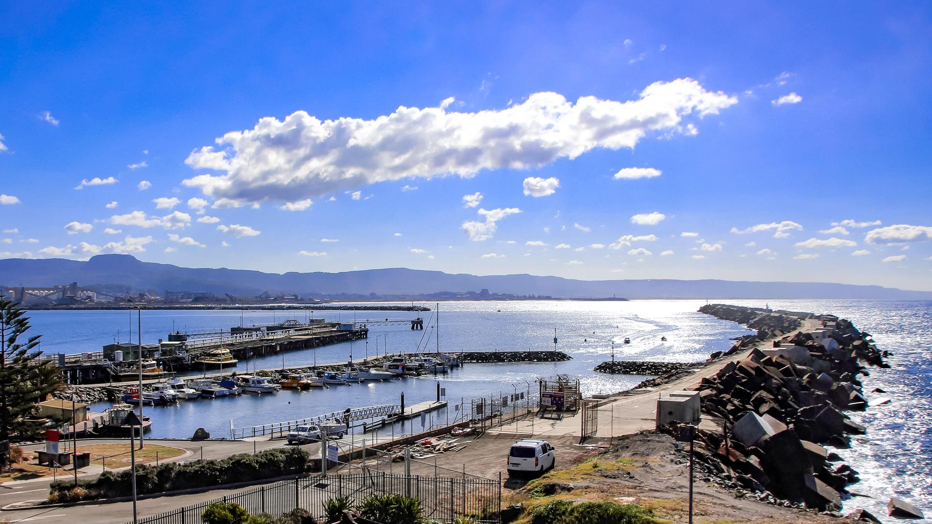 The bays in Port Kembla with vessels on the water and vehicles ashore