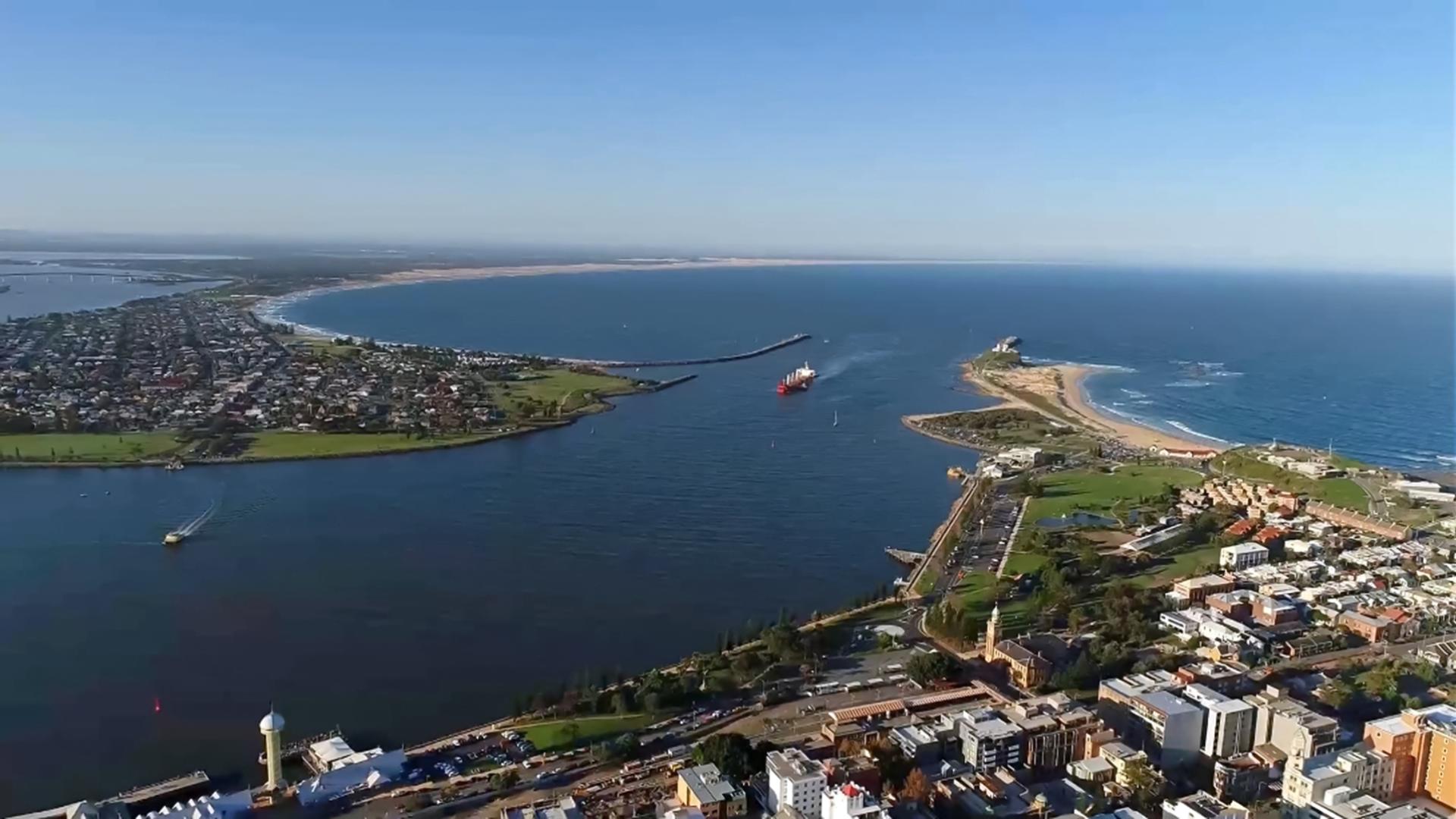 Aerial from the sky of a ship entering Port of Newcastle and surrounding areas