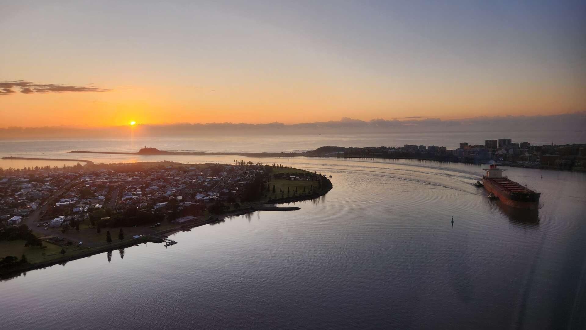 A large ship coming into Newcastle at sunrise