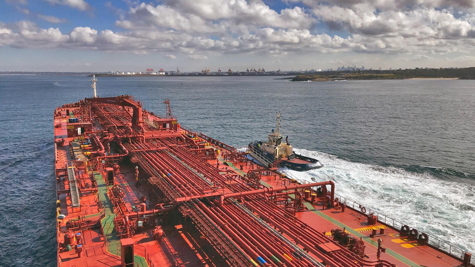 View above a tanker ship entering Port Botany with a tug alongside it