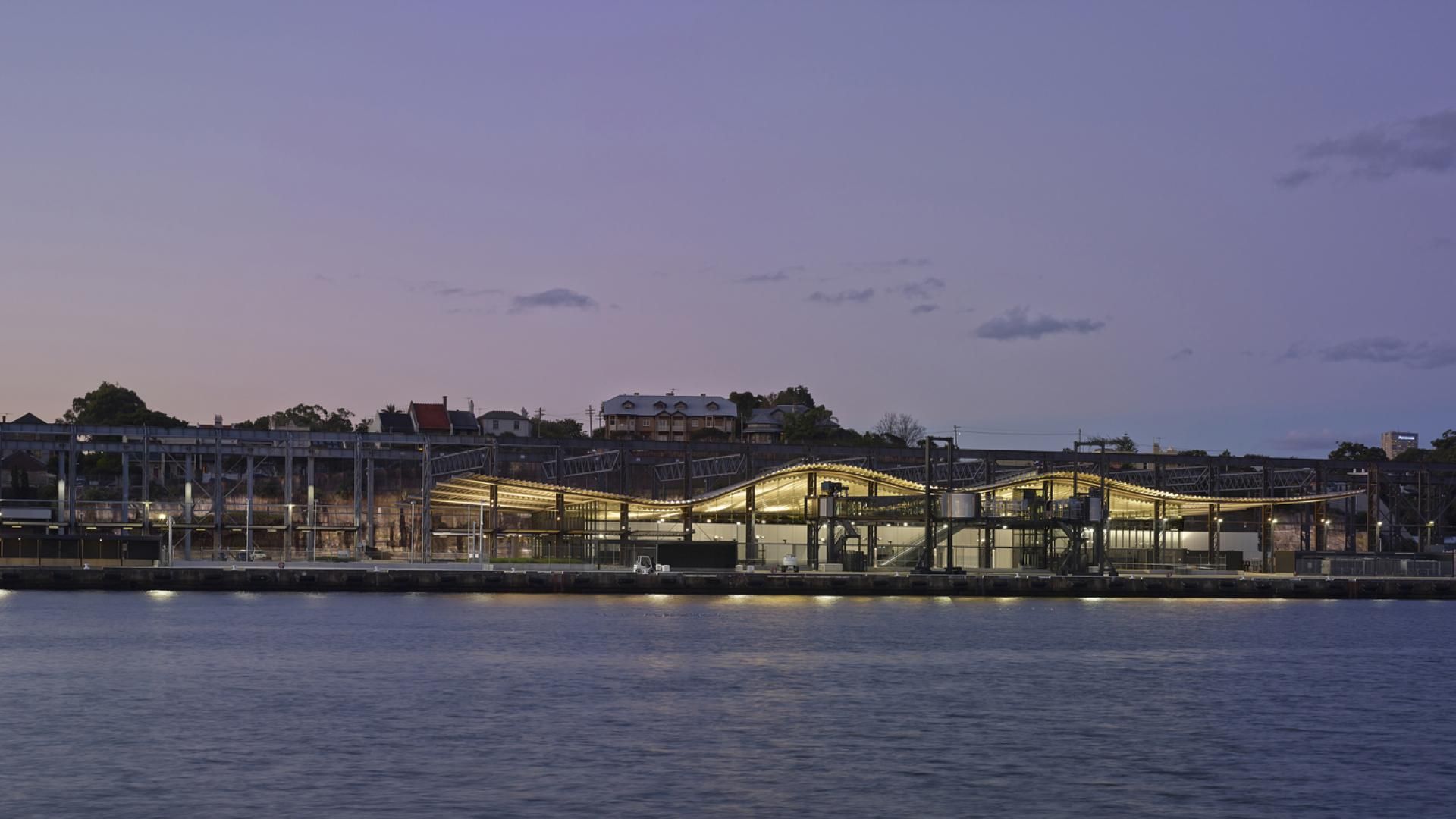 Looking across the water at White Bay Cruise Terminal at dusk illuminated by its lights on