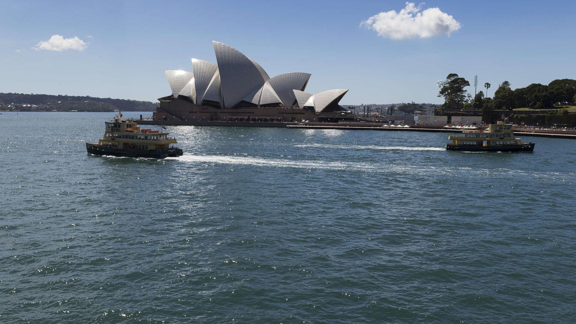 View from the Arrivals Hall on a sunny day showing the Opera House and ferries on the water