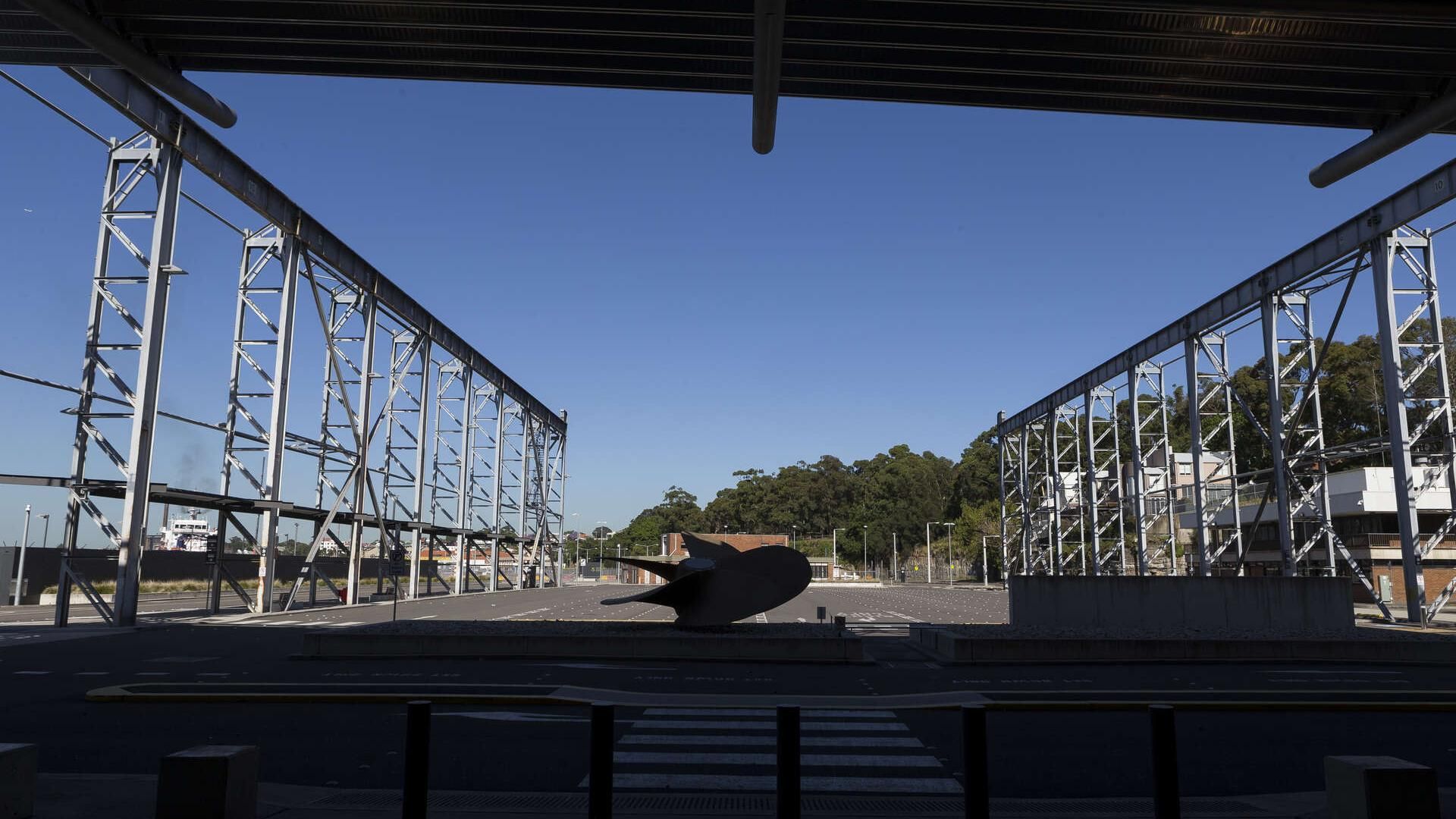 Looking at the empty car park covered by the shade of the White Bay Cruise Terminal behind
