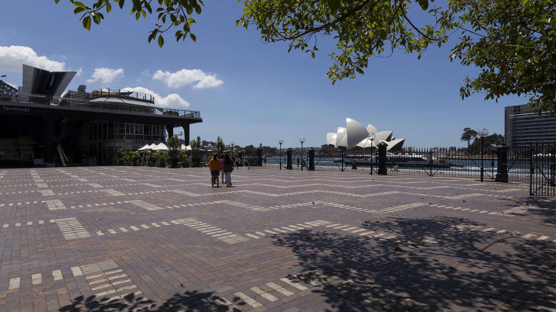 Standing on a paved area looking at the southern point of the Overseas Passenger Terminal and Opera House