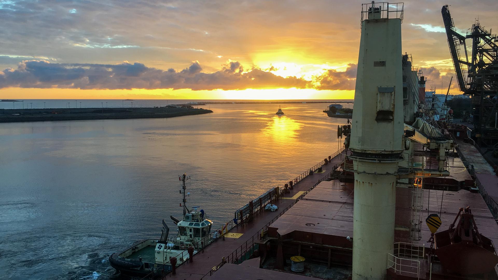 A vessel berthed at Port Kembla with a sunrise