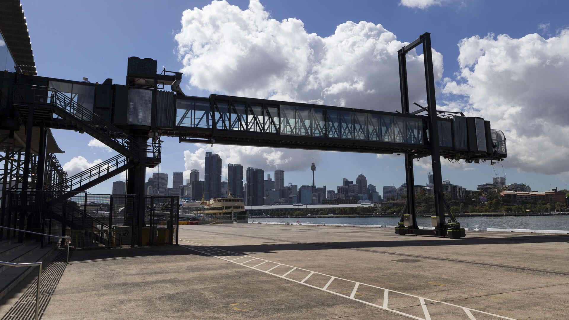 Standing on White Bay Cruise Terminal concrete area looking up at the protruding gangway with CBD in the distance
