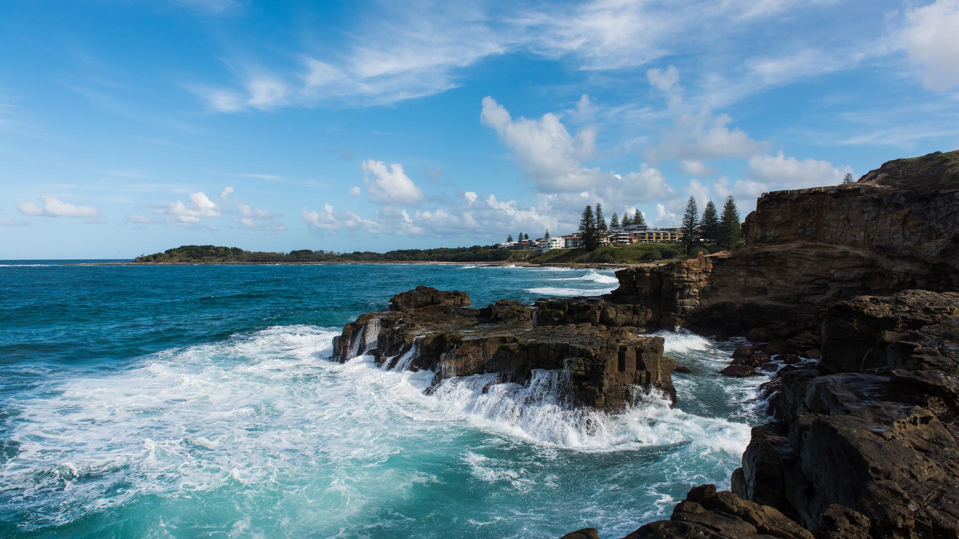 Cliffs on the Yamba coastline with foamy water from waves that recently crashed